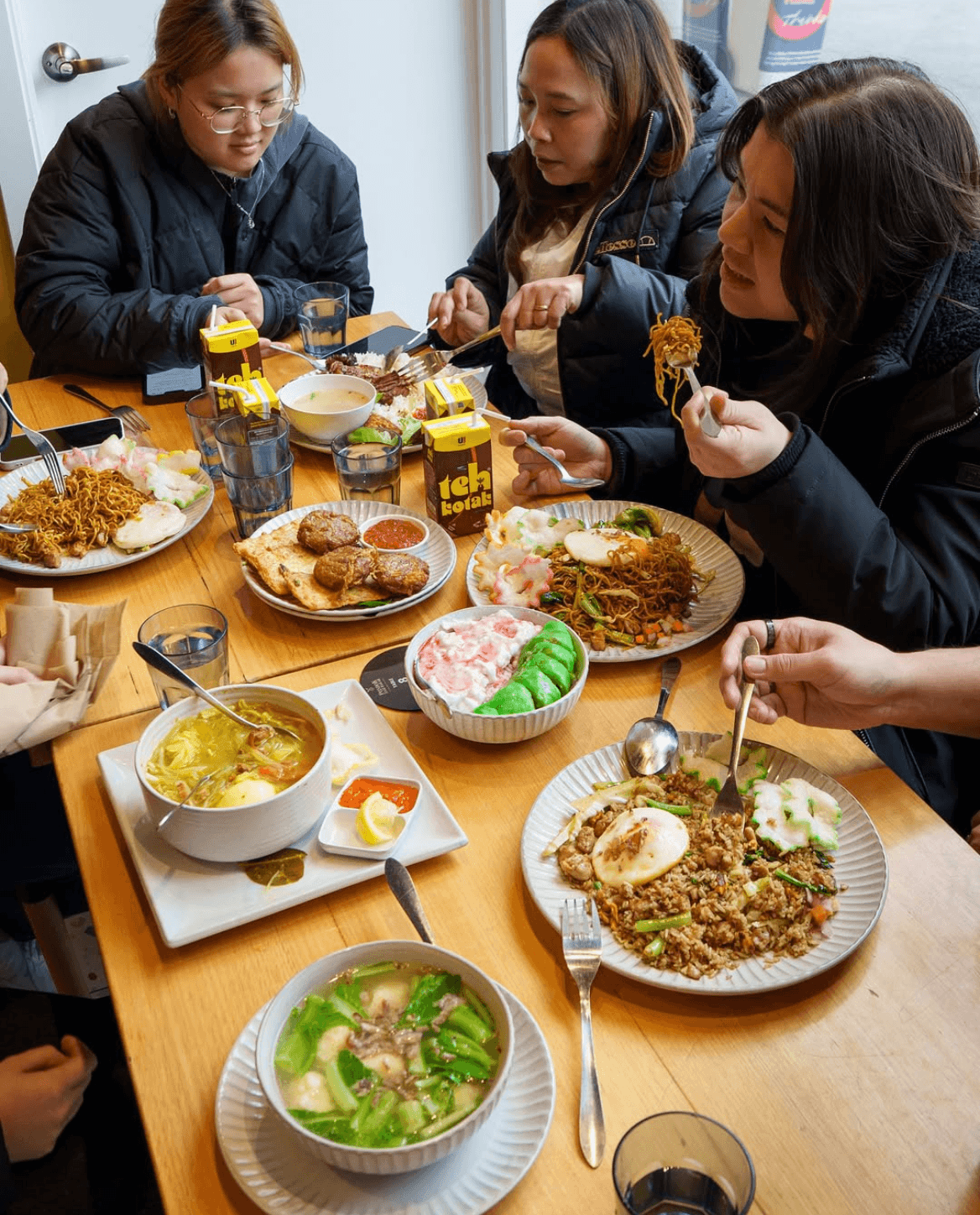 Customers enjoying authentic halal Indonesian food together at Pondok Nasi Bakar in South Melbourne